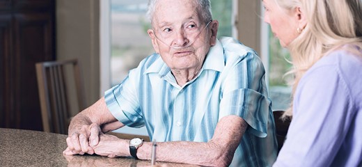 Patient on oxygen talks with his provider. 